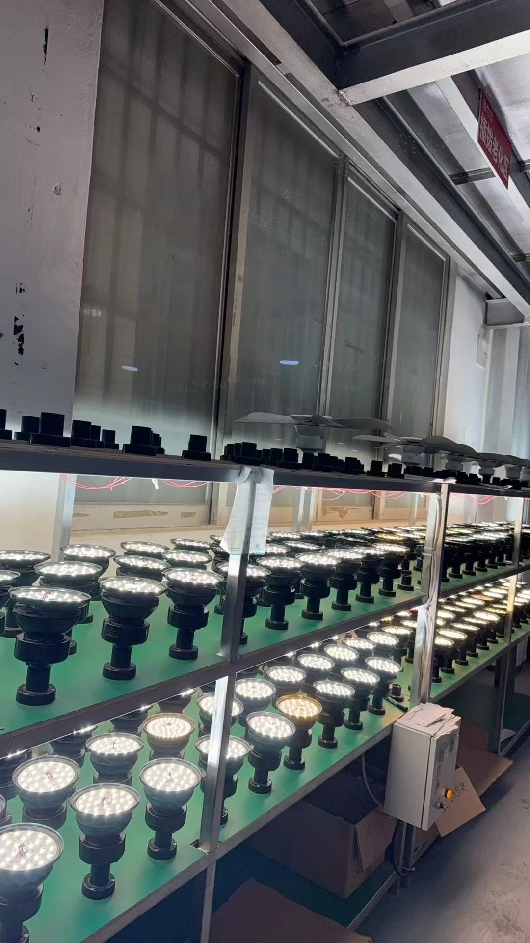 Rows of illuminated LED modules on two-tier factory test racks